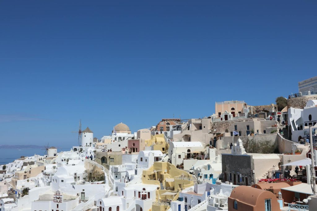 Beautiful view of Oia, Greece, featuring iconic whitewashed buildings under a clear blue sky.